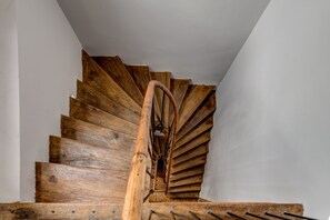 A wooden spiral staircase with a central handrail and metal balusters. - UPSTAIRS BOUTIQUE (Bucharest)
