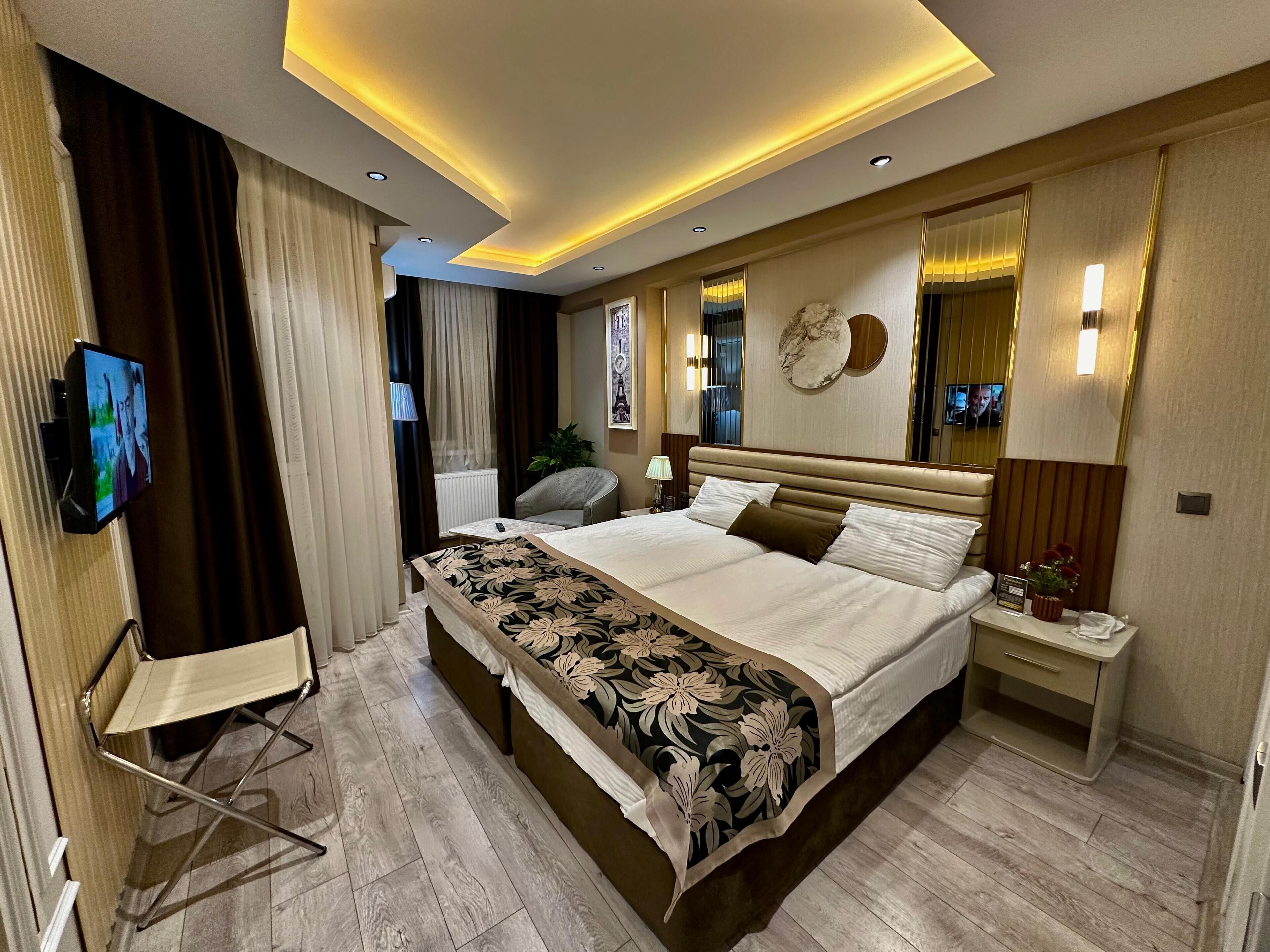 Une chambre d’hôtel moderne équipée d’un grand lit, d’un téléviseur à écran plat, d’un bureau et d’une chaise.