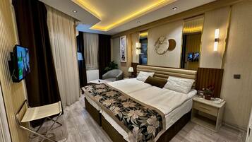 Une chambre d’hôtel moderne équipée d’un grand lit, d’un téléviseur à écran plat, d’un bureau et d’une chaise.