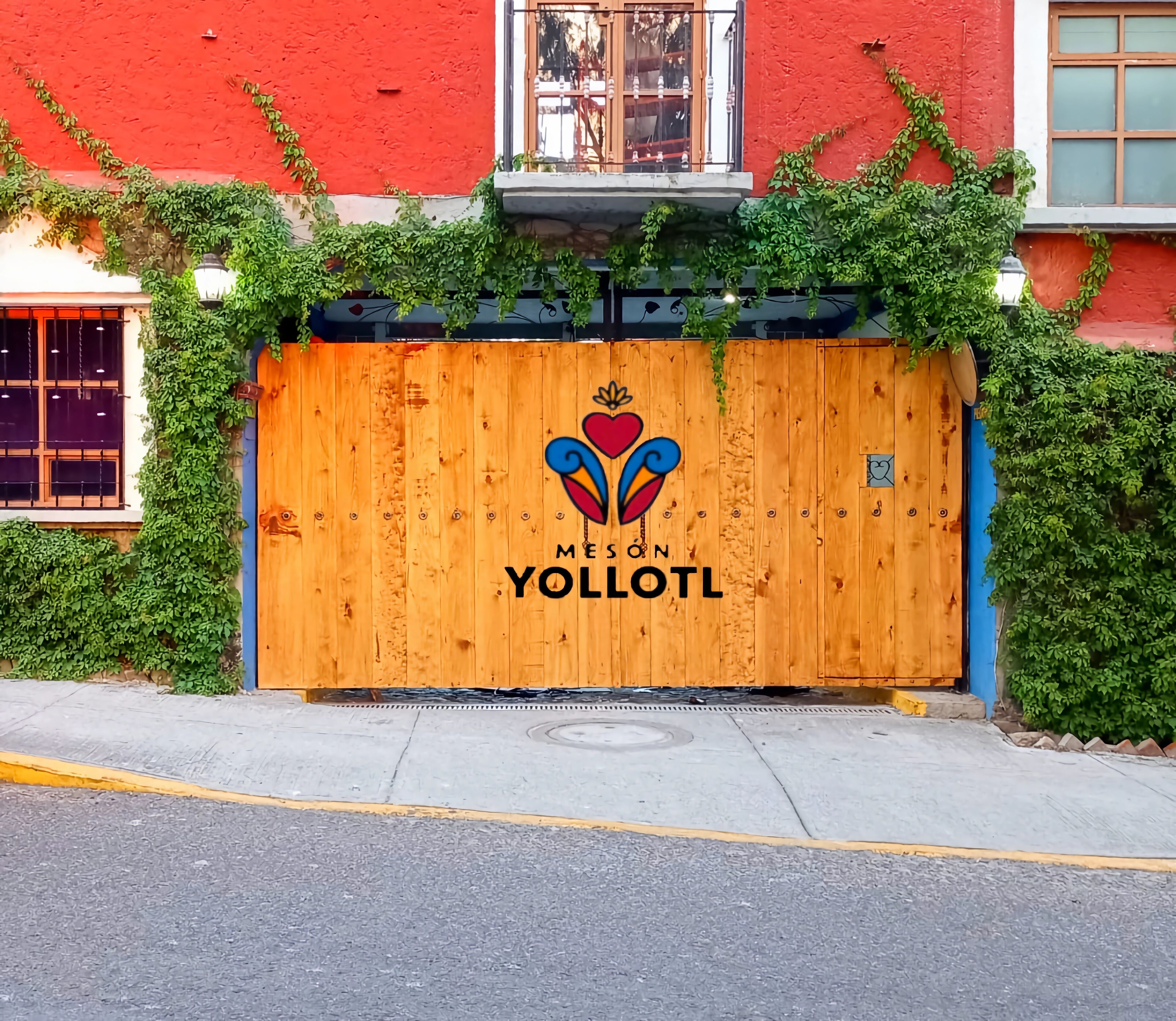 A wooden gate with a logo and the name 'MESON YOLLOTL' on it.