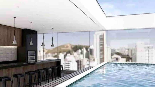 A modern indoor pool area with a bar and seating. - AP 1422 com Piscina, Academia e Coworking (Juiz de Fora)