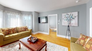 Ein Wohnzimmer mit einer Couch, einem Couchtisch und Kunstwerken an der Wand.
