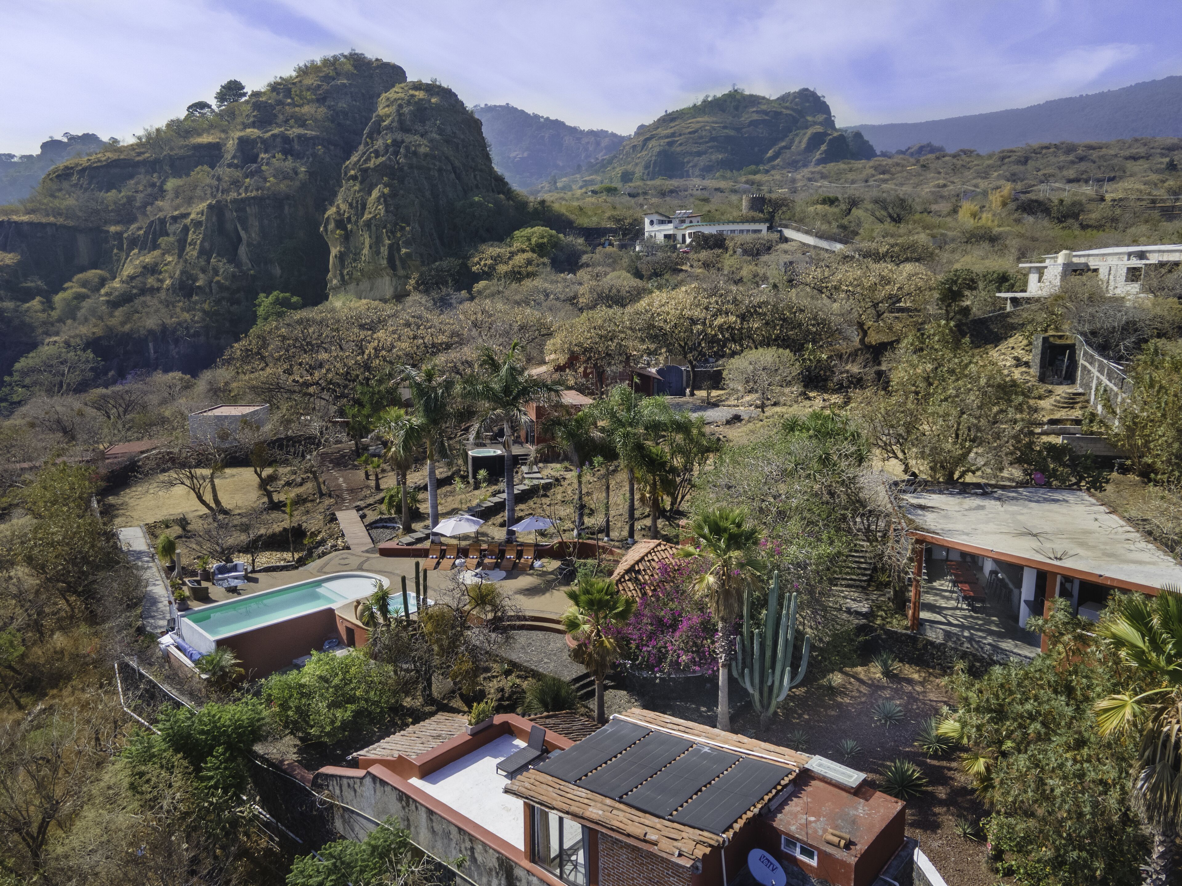 Un resort con piscina, tumbonas y vistas a las colinas circundantes.