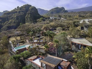 Un resort con piscina, tumbonas y vistas a las colinas circundantes.