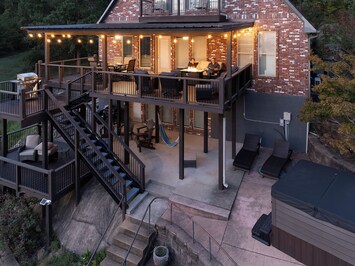 Stunning deck and patio area with ambient string lighting.