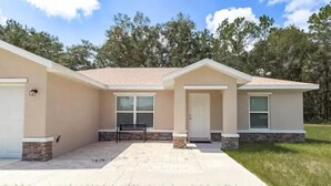 A two-story house with a front porch, a garage, and a stone foundation. - Peaceful Retreat  3 Bedroom  10 min to WEC (Marion County)