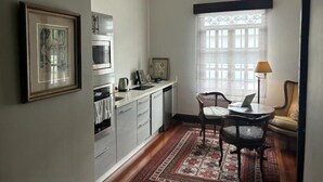 Eine kompakte Küche mit modernen Geräten, ein Essbereich mit Tisch und Stühlen sowie ein großes Fenster mit Blick.