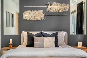 Relax in a serene bedroom with a large bed and minimalist decor.