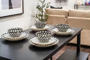 Enjoy meals in style with a beautifully set dining table, complete with matching bowls, plates, and saucers.