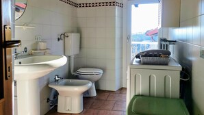 A bathroom with a toilet, bidet, sink, and a radiator. - A TERRACE IN THE GREEN apartment surrounded by nature, away from the hustle and bustle  (Lombardia)