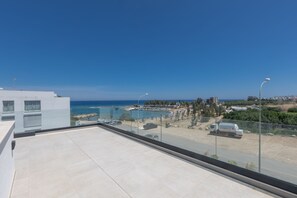 Une terrasse sur le toit offrant une vue dégagée sur la mer, un espace de stationnement et un camion SYNERGAS.