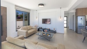 A modern living room with a sofa, coffee table, and TV.