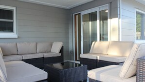 Un patio cubierto con dos sofás y una mesa de centro.