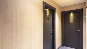 A hallway with two doors, each marked with a room number plaque. - Nora Airport Hotel Istanbul  (Arnavutköy)