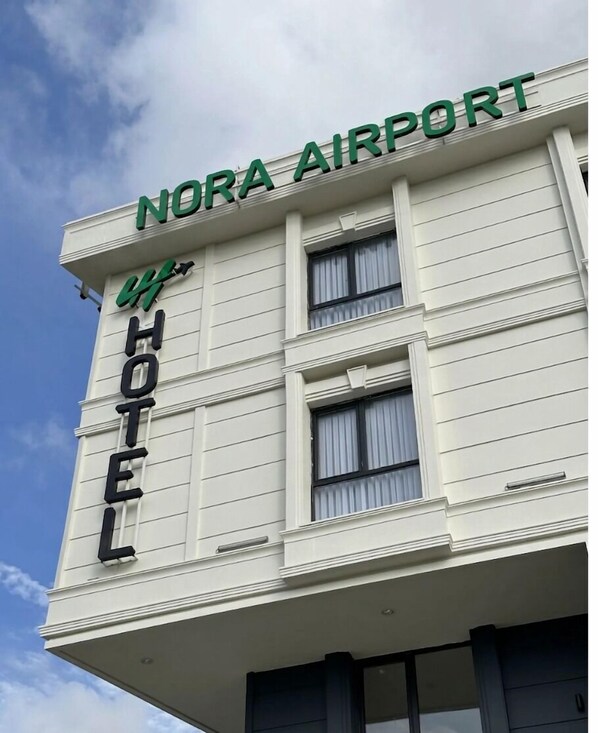 Un edificio con un cartel que dice 'NORA AIRPORT HOTEL'.