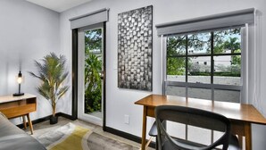 A modern room with a desk, chair, and a large window.