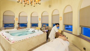 A spa room with a large bathtub, arched windows, and a view of the sea. - Spectacular Ocean View Suite for the Holidays on the Beach!  (Cabo San Lucas)
