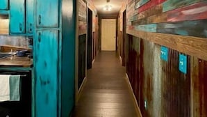 A narrow hallway with wooden paneling on the walls and a wooden floor.