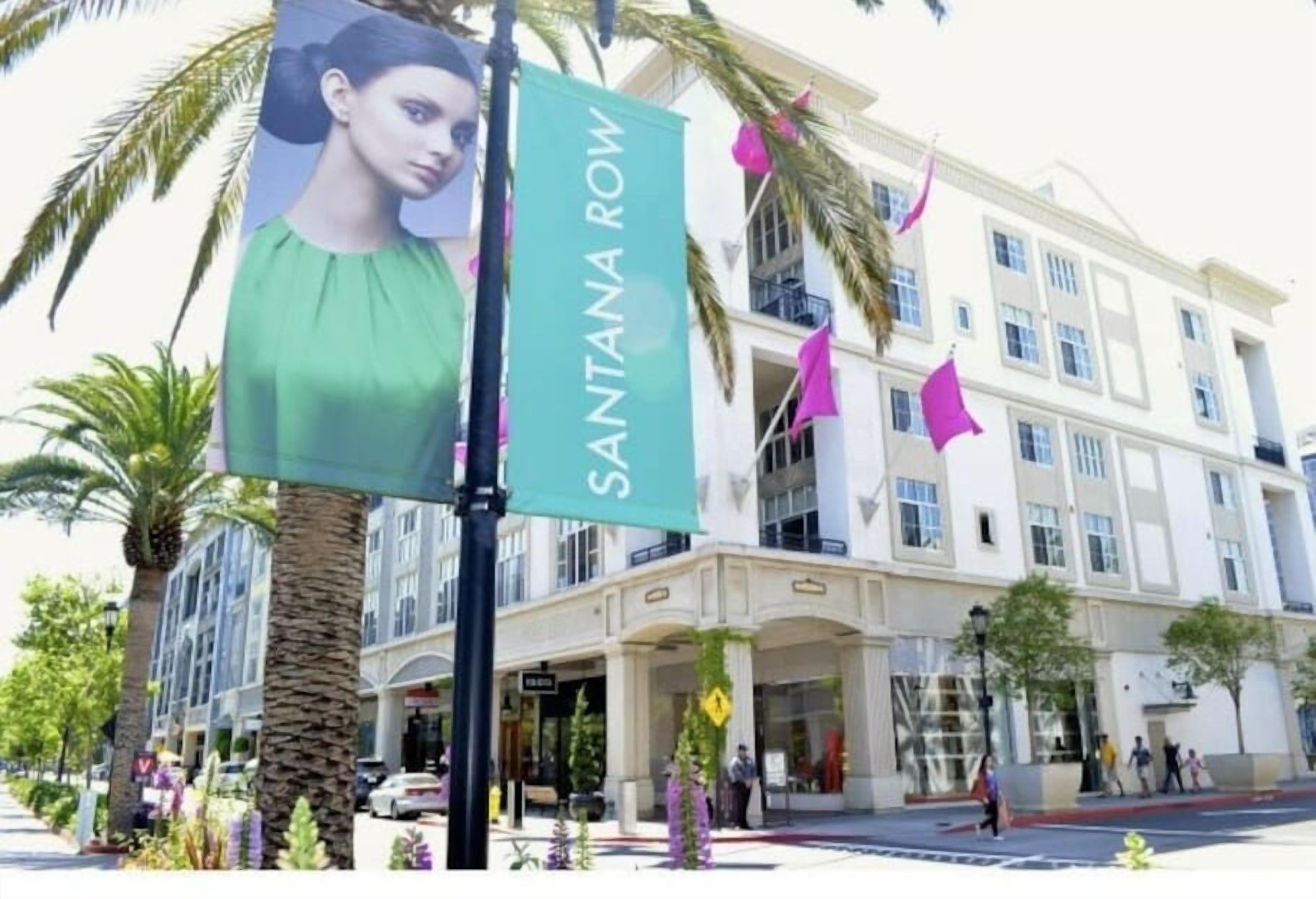 Ein Hotel mit einem Schild, auf dem "SANTANA ROW" steht, und einer Fassade mit mehreren Fenstern und Balkonen.