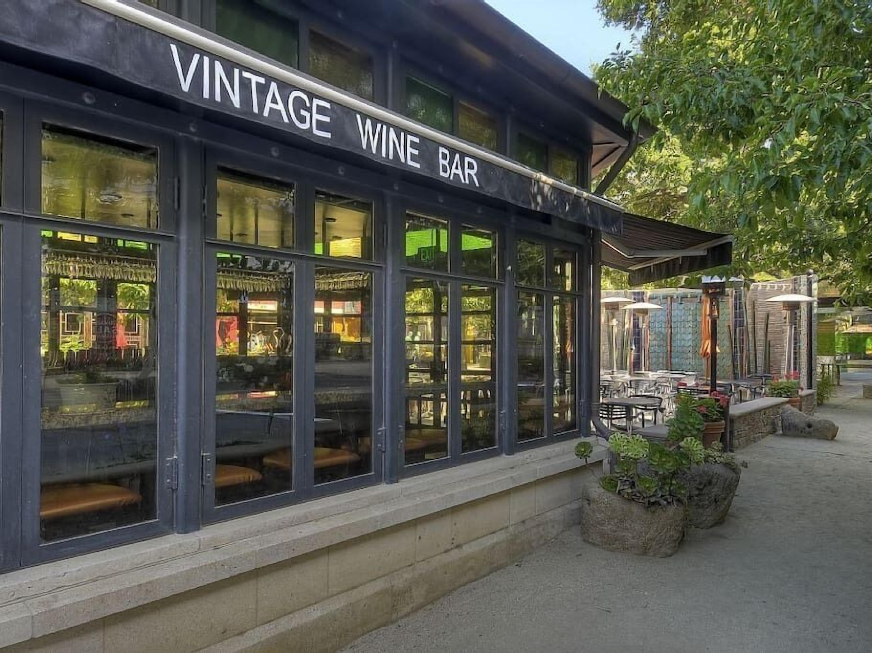 A vintage wine bar with large windows and outdoor seating.