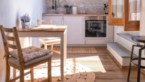 Une cuisine moderne avec des meubles en bois, un four encastré et une grande horloge au mur.