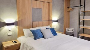 Un dormitorio con cama, mesitas de noche y un armario.