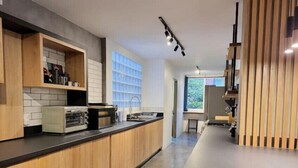 Una cocina moderna con armarios de madera, encimera negra y horno empotrado.
