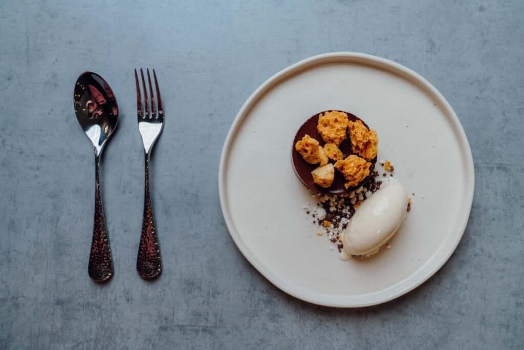 En desserttallerken med en chokoladedessert og en portion is.