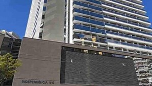 Un edificio moderno con un design architettonico slanciato, caratterizzato da una serie di balconi e un'area d'ingresso ben definita.