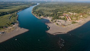Vue aérienne d’une zone côtière avec une rivière, une plage et des immeubles résidentiels.