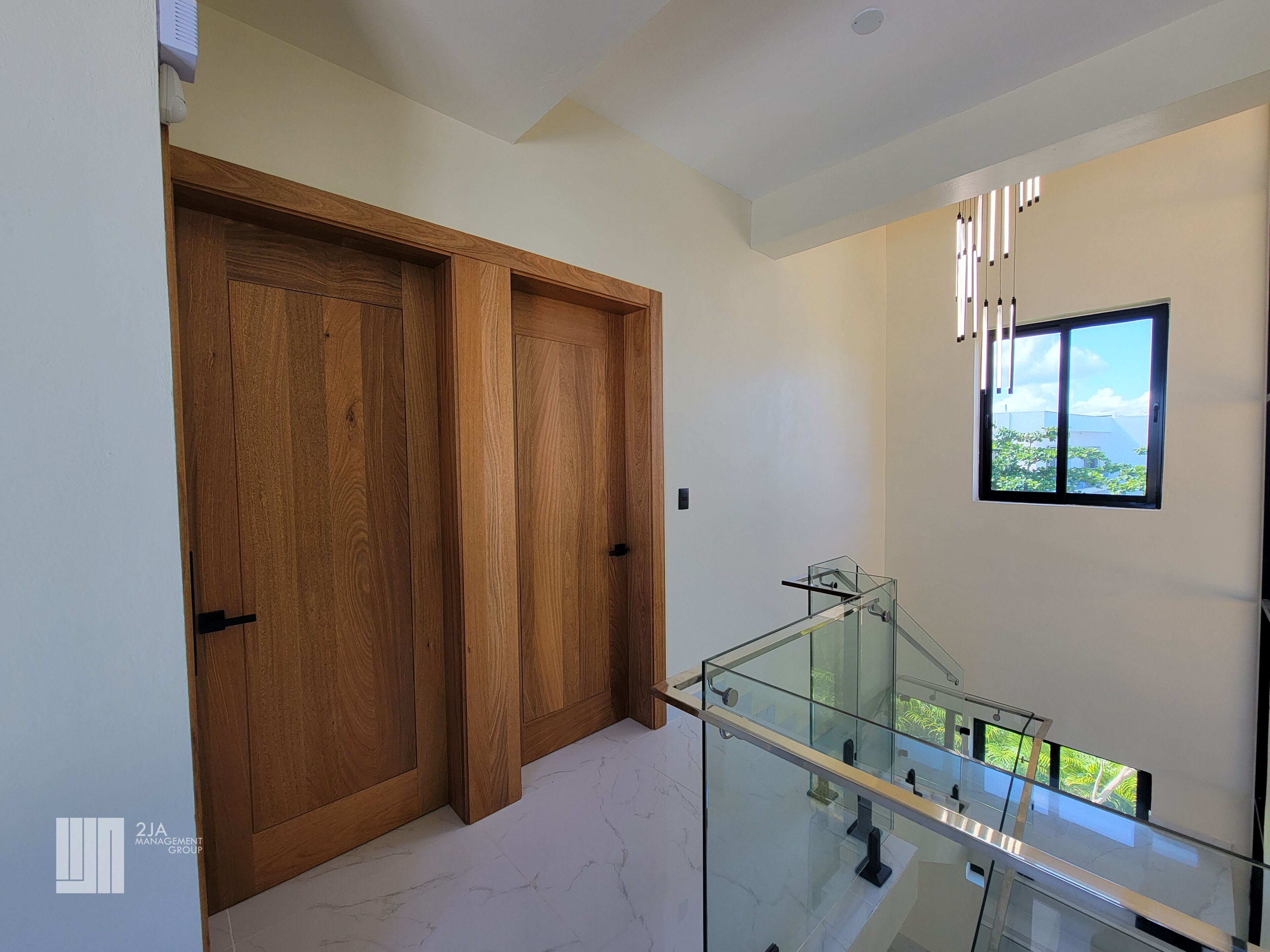 Ein modernes Interieur mit Holztür, Glastrennwand und Fenster mit Blick.