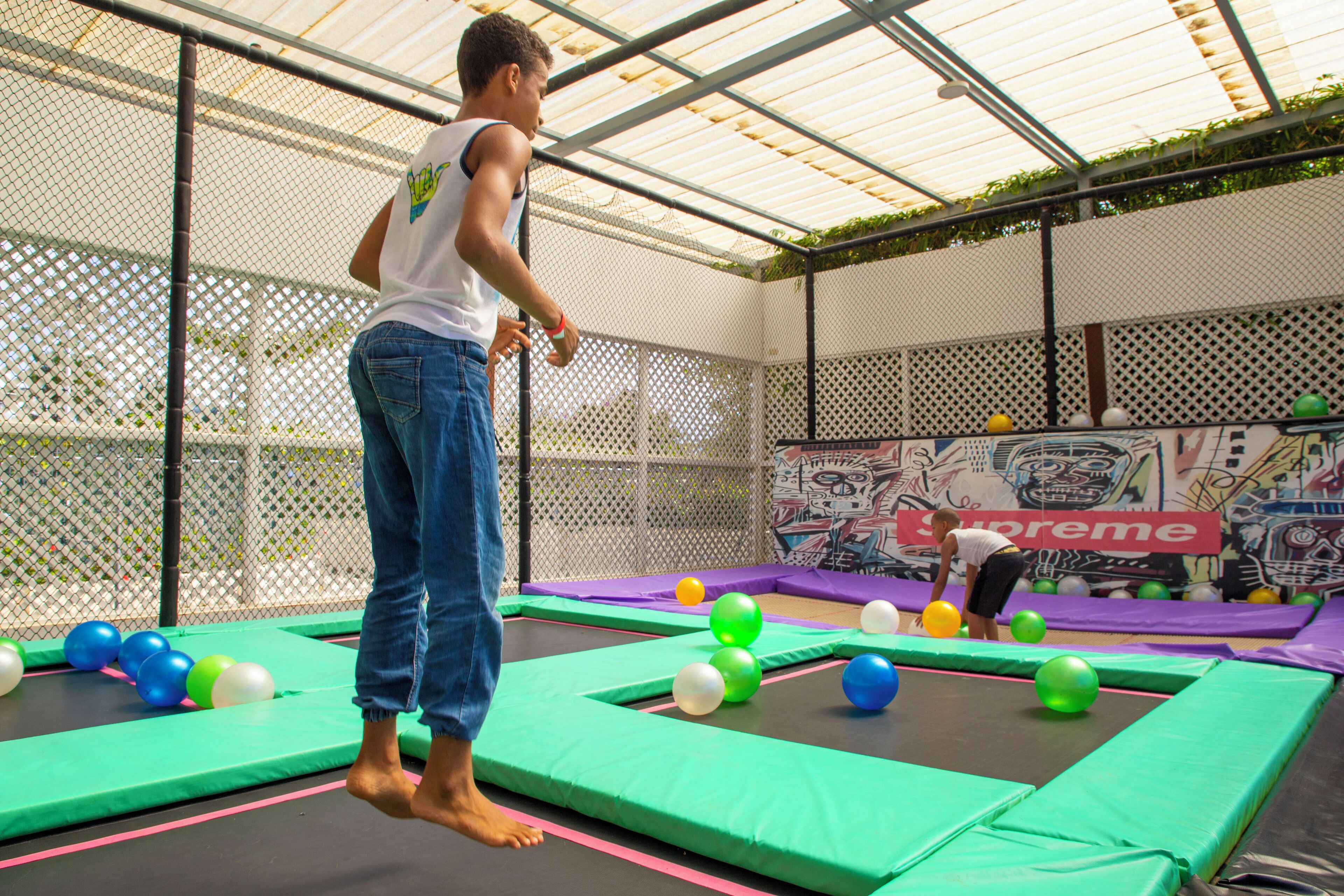 A trampoline area with safety padding and colorful balls.
