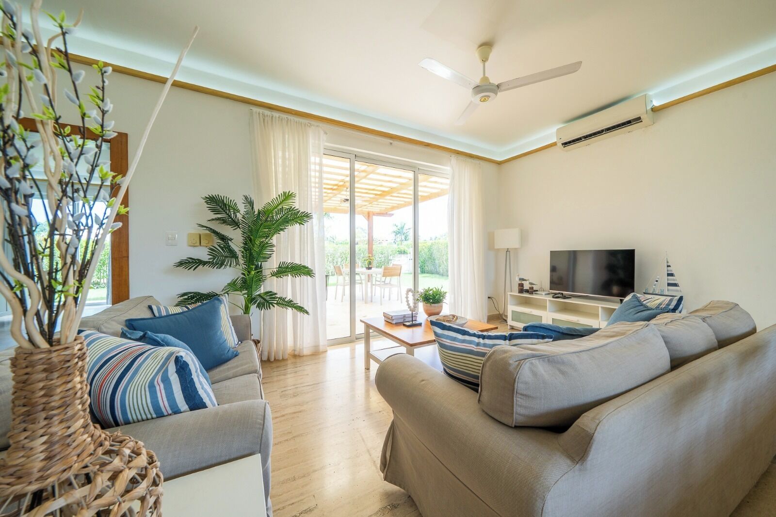 A modern living room with a sofa set, a television, and a large window.