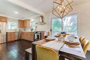 A modern kitchen with wooden cabinets, stainless steel appliances, and a large window providing natural light. - Midcentury Lake Home! (White Bear Lake)