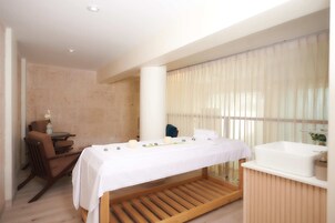 A modern bathroom with a wooden bench, a large bathtub, and a glass-enclosed shower area.