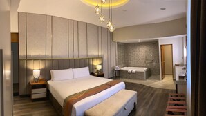 A modern hotel room with a large bed, bedside lamps, a bathroom with a bathtub, and a shower. - ARIQUEPAY HOTEL (Arequipa)
