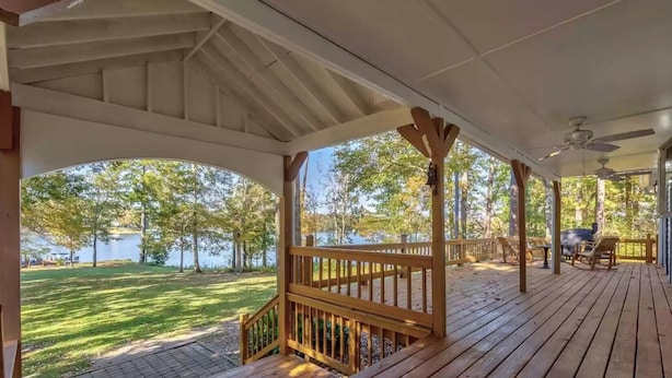 A covered deck with a view of a lake, wooden railings, and outdoor seating. - 5 Bdrm, Amazing Sunsets, deck, flat yard, dock, fish, beach, kayaks... (Sparta)
