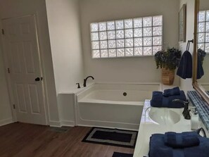 A bathroom with a bathtub, a sink, a window with frosted glass, and a potted plant. - 5 Bdrm, Amazing Sunsets, deck, flat yard, dock, fish, beach, kayaks... (Sparta)