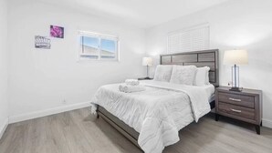 A bedroom with a bed, bedside tables, a window, and wall art. - Comfy 2BR Apt w/ AC/Washer/Dryer/EV - in Sunnyvale (Sunnyvale)