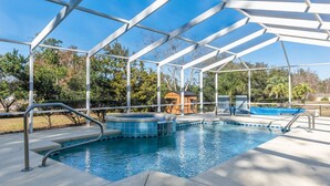 A covered outdoor swimming pool with a hot tub, surrounded by trees and a gazebo. - Inverness Poolside Oasis 3 Bedroom (Inverness)