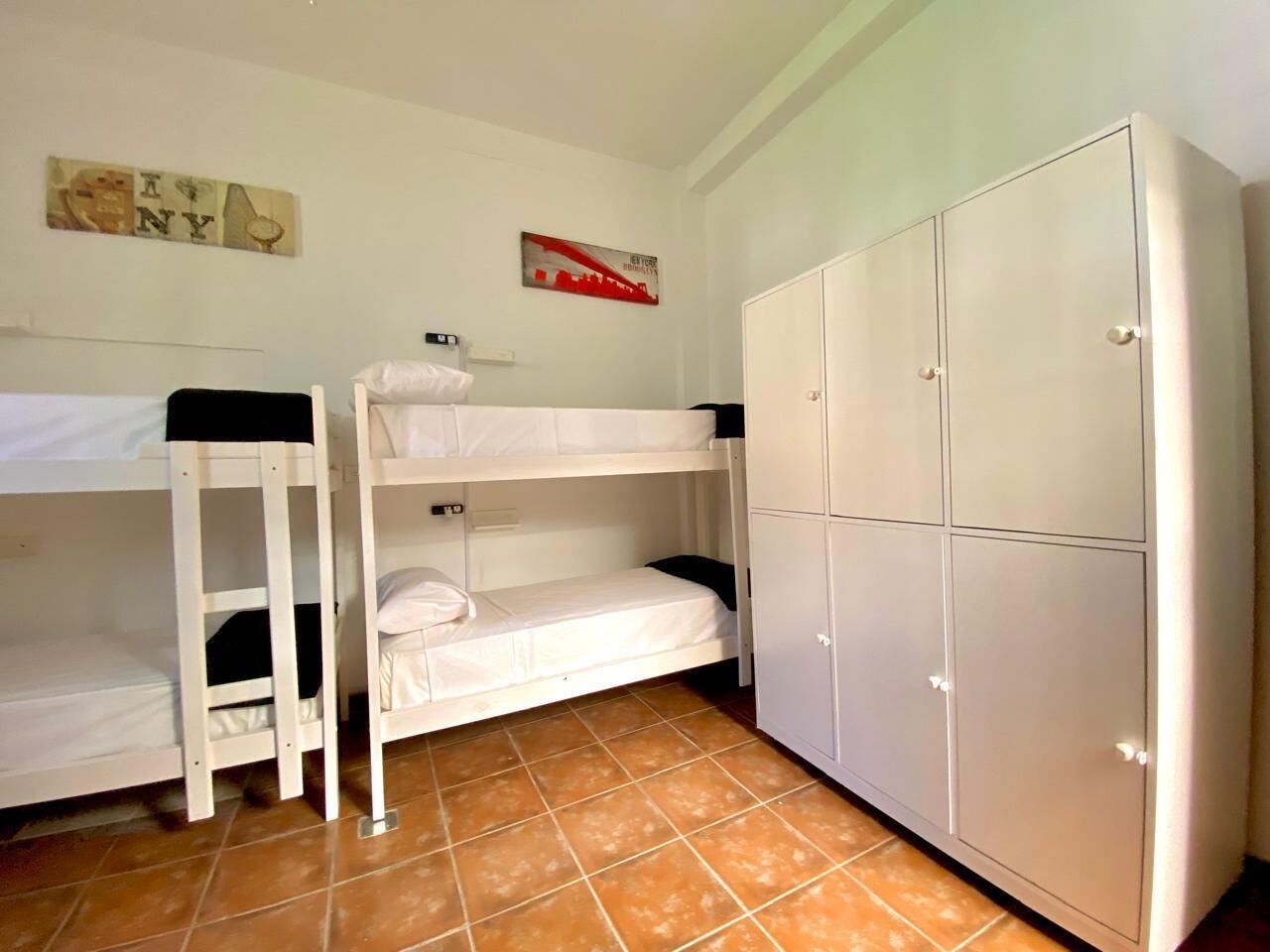 Habitación con literas, un armario y un adorno en la pared.