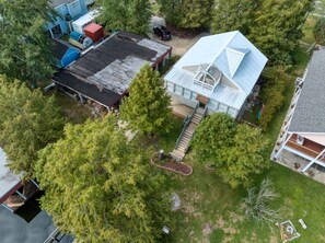 A residential property with a large house featuring a prominent staircase, a garage, and a well-maintained lawn.
