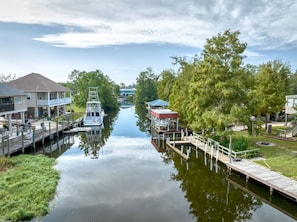 A canal with a boat docked on the left, a covered dock on the right, and houses on both sides.