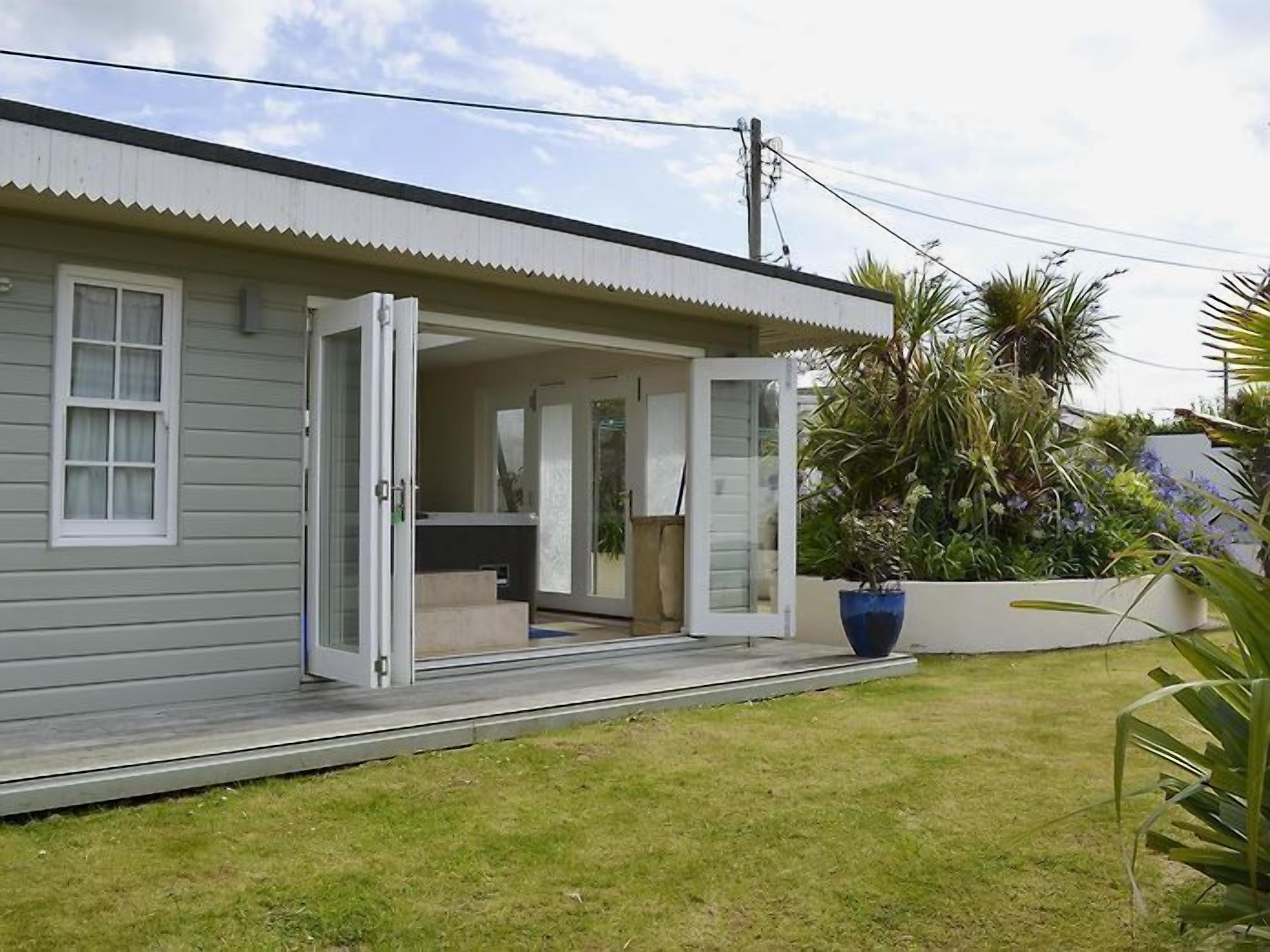 A single-story house with a covered porch and a small outdoor seating area.