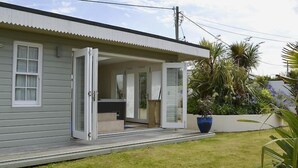 A single-story house with a covered porch and a small outdoor seating area.