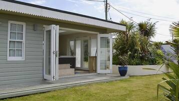 A single-story house with a covered porch and a small outdoor seating area.
