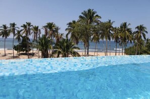 Relax by the pool overlooking the ocean and sandy beach.