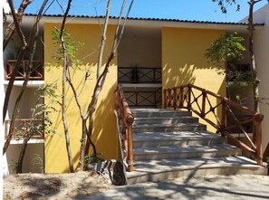 Staircase leads to a building with a tiled roof, surrounded by lush greenery.