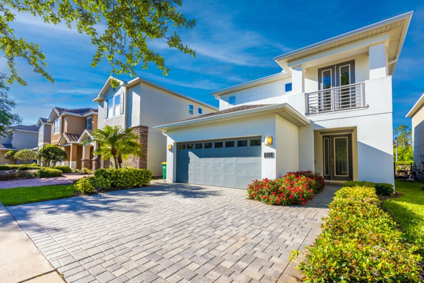 A modern two-story house with a garage, paved driveway, and well-maintained landscaping.