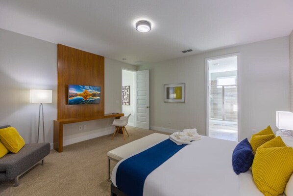 Habitación de hotel moderna con una cama grande, un escritorio y vistas al exterior.